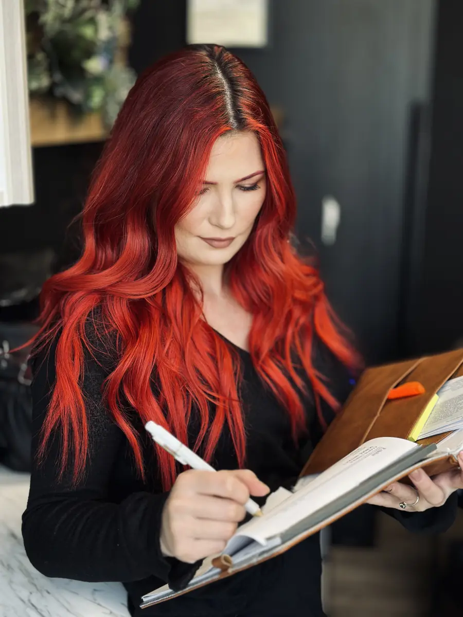Timillia writing a client's hair plan in her notebook